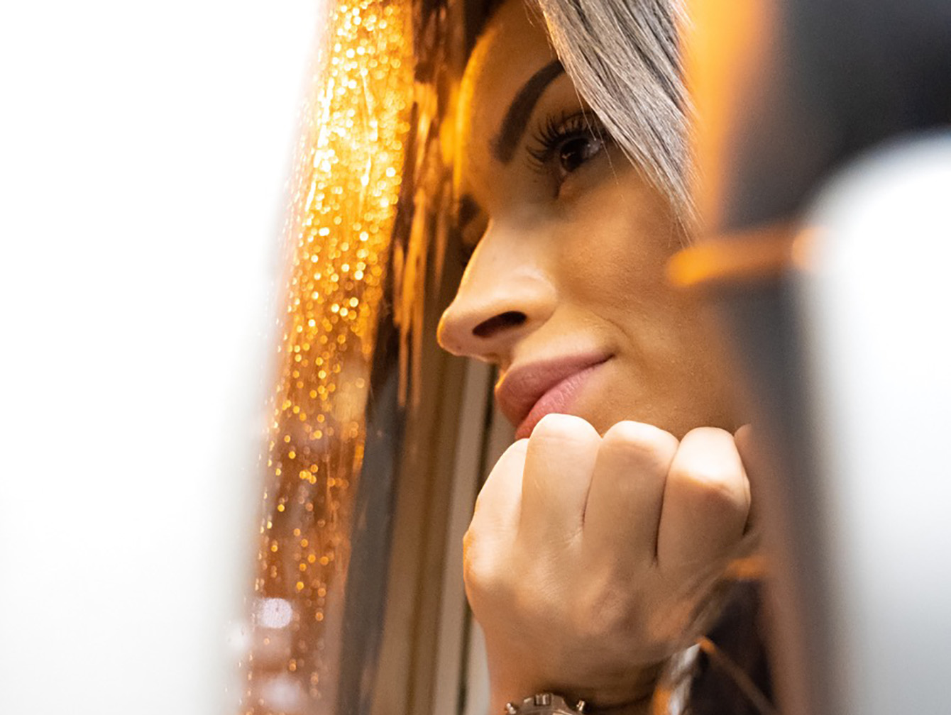 A contemplative woman gazing out a window with raindrops